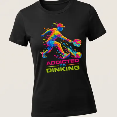 Colorful illustration of a pickleball player with dynamic splash art and text — printed on a women's shirt