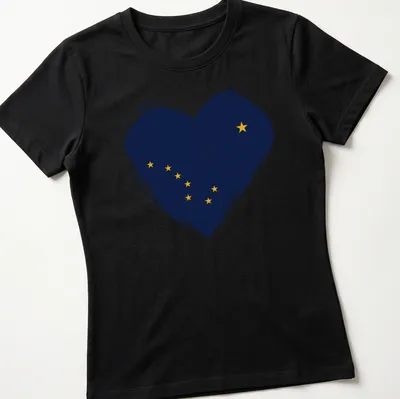 Distressed print of Alaska flag in heart shape, navy blue and yellow — printed on a women's shirt