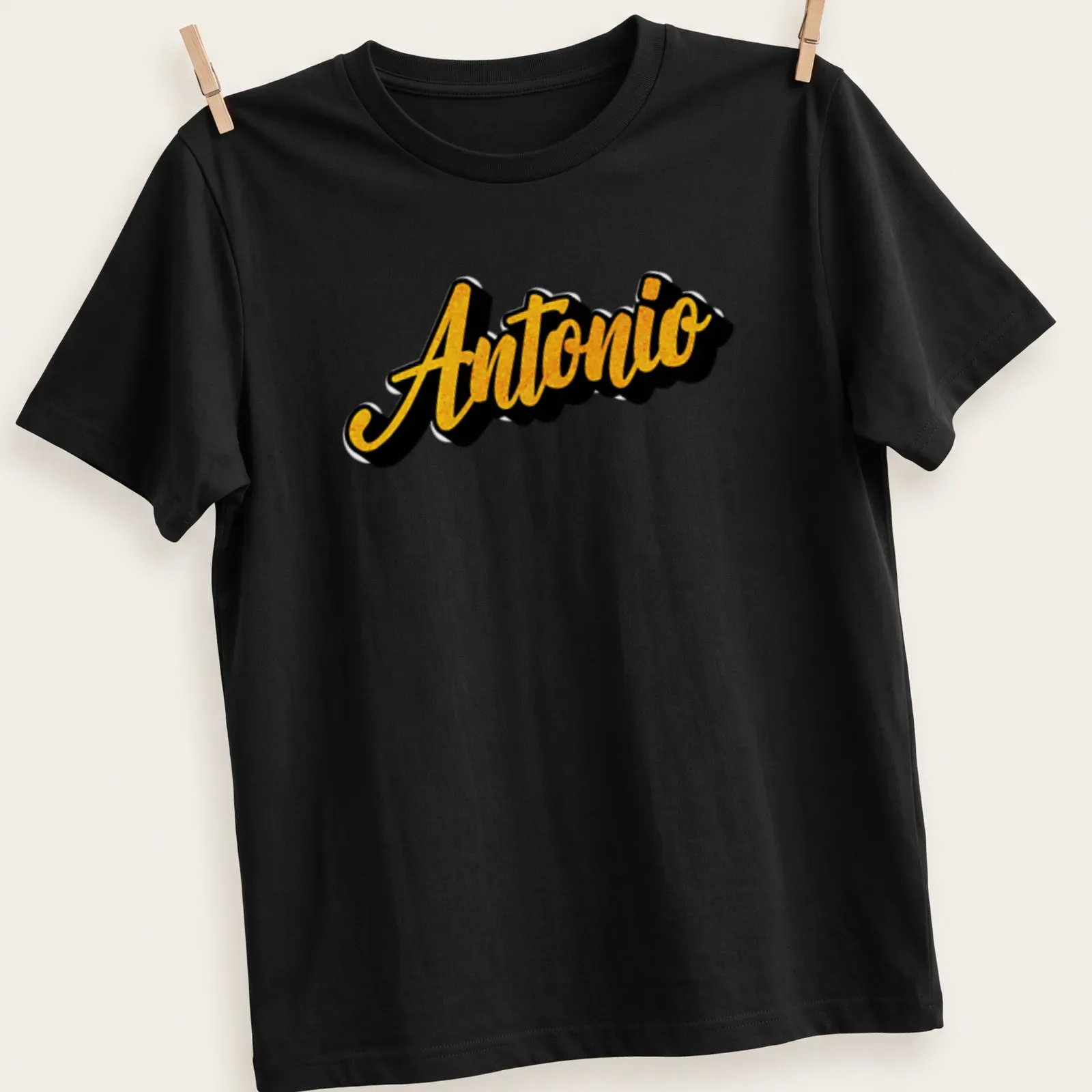 Bold script t-shirt featuring the name Antonio in gold on black. — printed on a unisex t-shirt