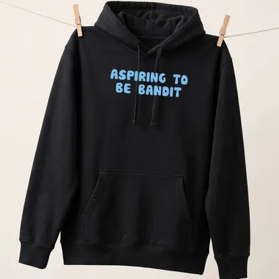 Playful bubble letters spelling ASPIRING TO BE BANDIT on light blue background — printed on a unisex hoodie