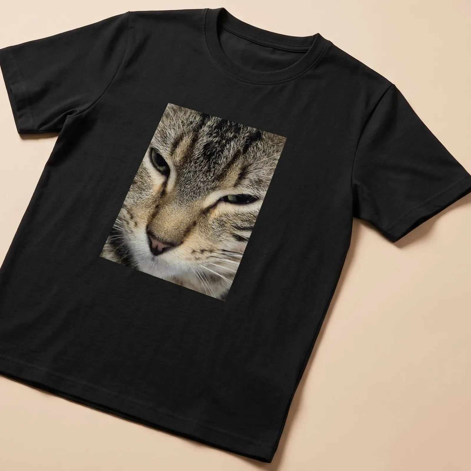 Realistic close-up of a cat's face in brown, gray, black, and white — printed on a unisex t-shirt