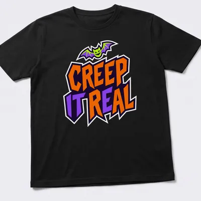 Cartoon bat graphic with Creep It Real text in Halloween colors — printed on a unisex t-shirt