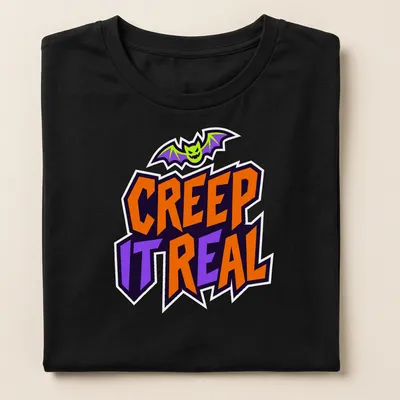 Cartoon bat graphic with Creep It Real text in Halloween colors — printed on a women's shirt