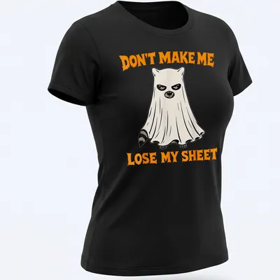 Cartoon ghost raccoon with humorous text about losing a sheet in orange, black, and white — printed on a women's shirt