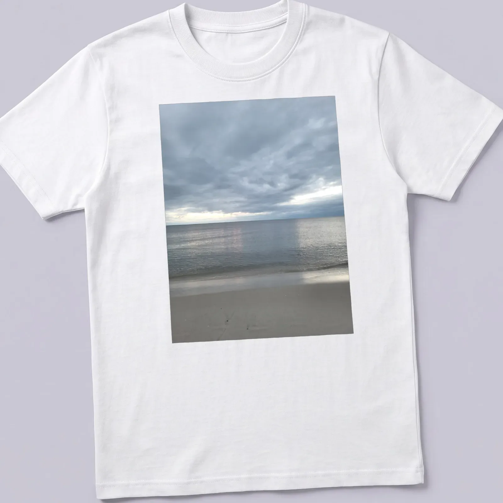 Photographic print of a dramatic bay view in gray, blue, and beige hues — printed on a unisex t-shirt