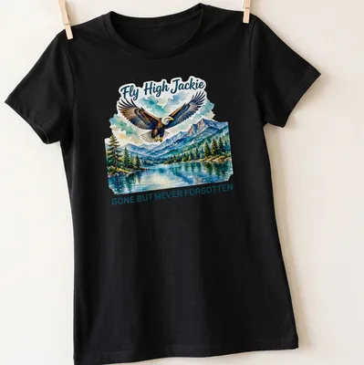 Watercolor print T-shirt featuring a bald eagle and the text Fly High Jackie GONE BUT NEVER FORGOTTEN — printed on a women's shirt