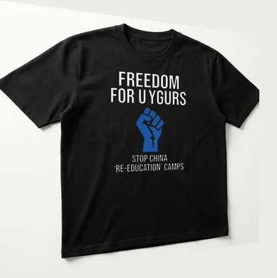 Bold graphic T-shirt with text calling for Uyghur freedom and a raised fist — printed on a unisex t-shirt (angled view)