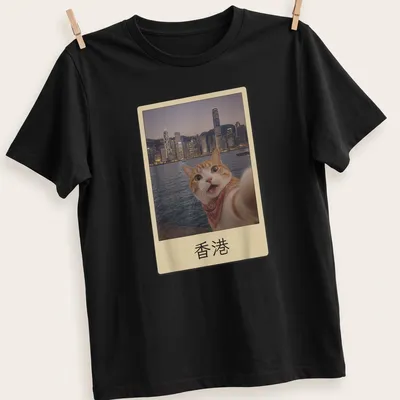Orange tabby cat selfie with Hong Kong cityscape, colorful photographic print — printed on a unisex t-shirt