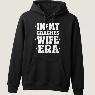 Bold typography t-shirt with IN MY COACHES WIFE ERA text in white — printed on a unisex hoodie
