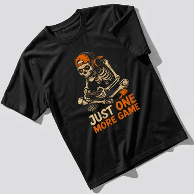 Cartoon skeleton playing video games with the text 'JUST ONE MORE GAME' in fun lettering. — printed on a unisex t-shirt