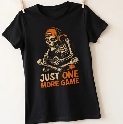 Cartoon skeleton playing video games with the text 'JUST ONE MORE GAME' in fun lettering. — printed on a women's shirt