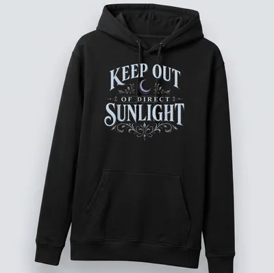 Vintage dark humor t-shirt featuring a moon and floral elements with the text 'KEEP OUT OF DIRECT SUNLIGHT' — printed on a unisex hoodie