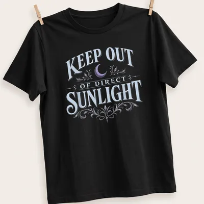 Vintage dark humor t-shirt featuring a moon and floral elements with the text 'KEEP OUT OF DIRECT SUNLIGHT'