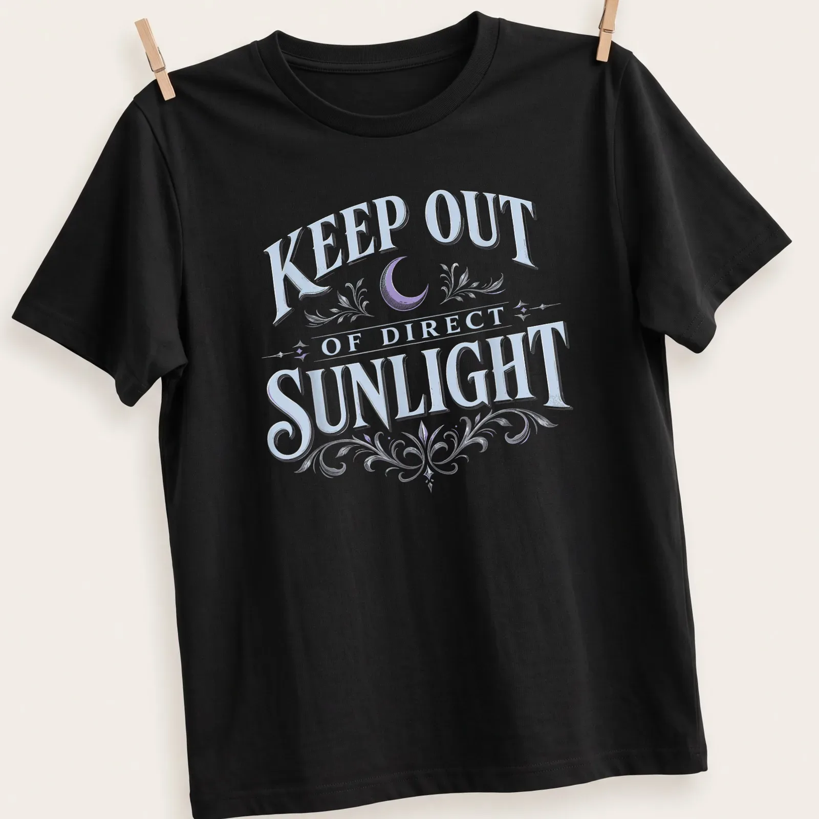 Vintage dark humor t-shirt featuring a moon and floral elements with the text 'KEEP OUT OF DIRECT SUNLIGHT' — printed on a unisex t-shirt