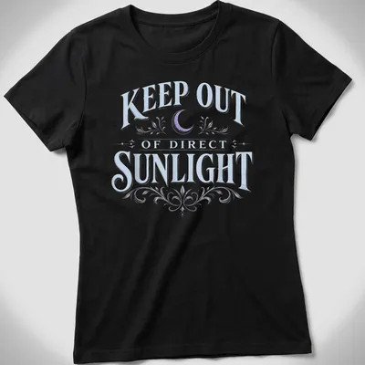 Vintage dark humor t-shirt featuring a moon and floral elements with the text 'KEEP OUT OF DIRECT SUNLIGHT' — printed on a women's shirt