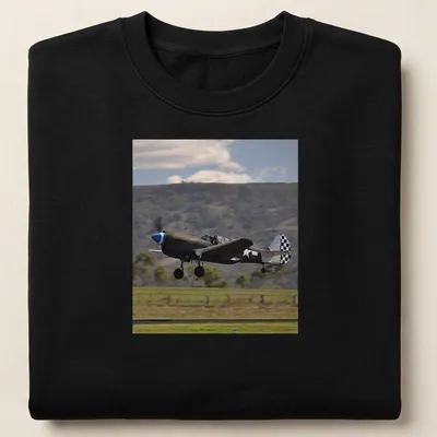 Photographic print of a Kittyhawk airplane taking off against a blue sky — printed on a unisex sweatshirt