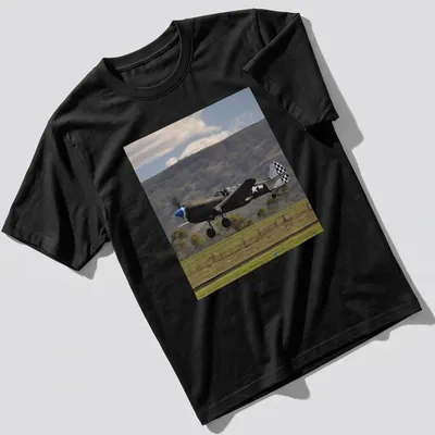 Photographic print of a Kittyhawk airplane taking off against a blue sky — printed on a unisex t-shirt