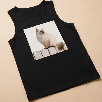 Realistic illustration of a Siamese cat sitting on a wooden fence against a blue sky. — printed on a tank top