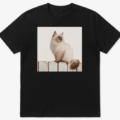 Realistic illustration of a Siamese cat sitting on a wooden fence against a blue sky. — printed on a unisex t-shirt