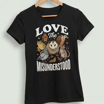 Illustrative t-shirt featuring various misunderstood animals with heartfelt text — printed on a women's shirt