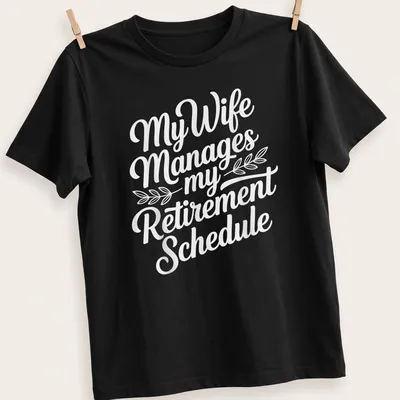 Funny t-shirt with script typography reading 'My Wife Manages my Retirement Schedule' — printed on a unisex t-shirt