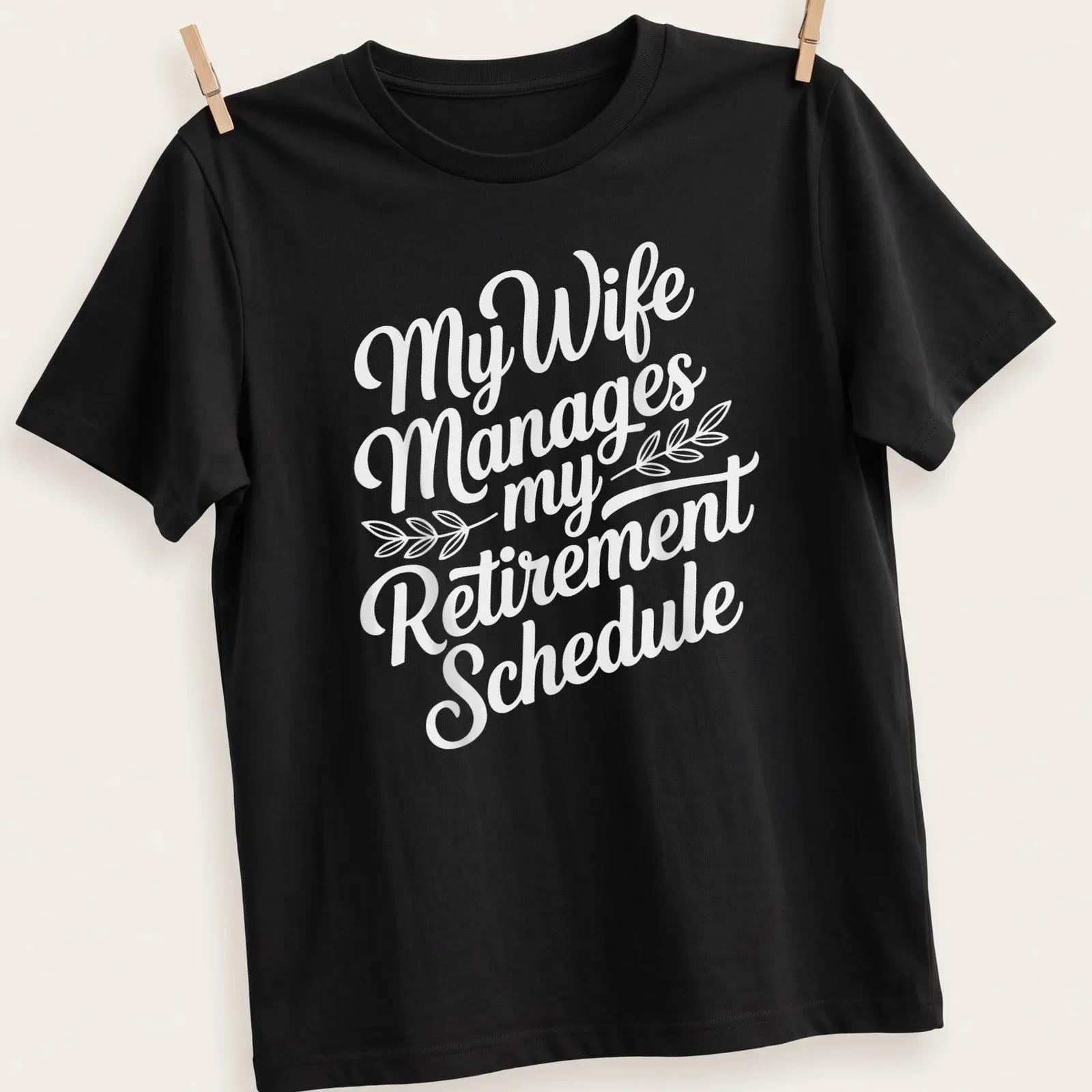 Funny t-shirt with script typography reading 'My Wife Manages my Retirement Schedule' — printed on a unisex t-shirt
