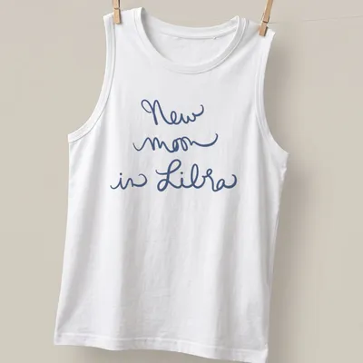 Handwritten script of 'New moon in Libra' on a navy blue — printed on a tank top