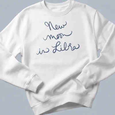 Handwritten script of 'New moon in Libra' on a navy blue — printed on a unisex sweatshirt