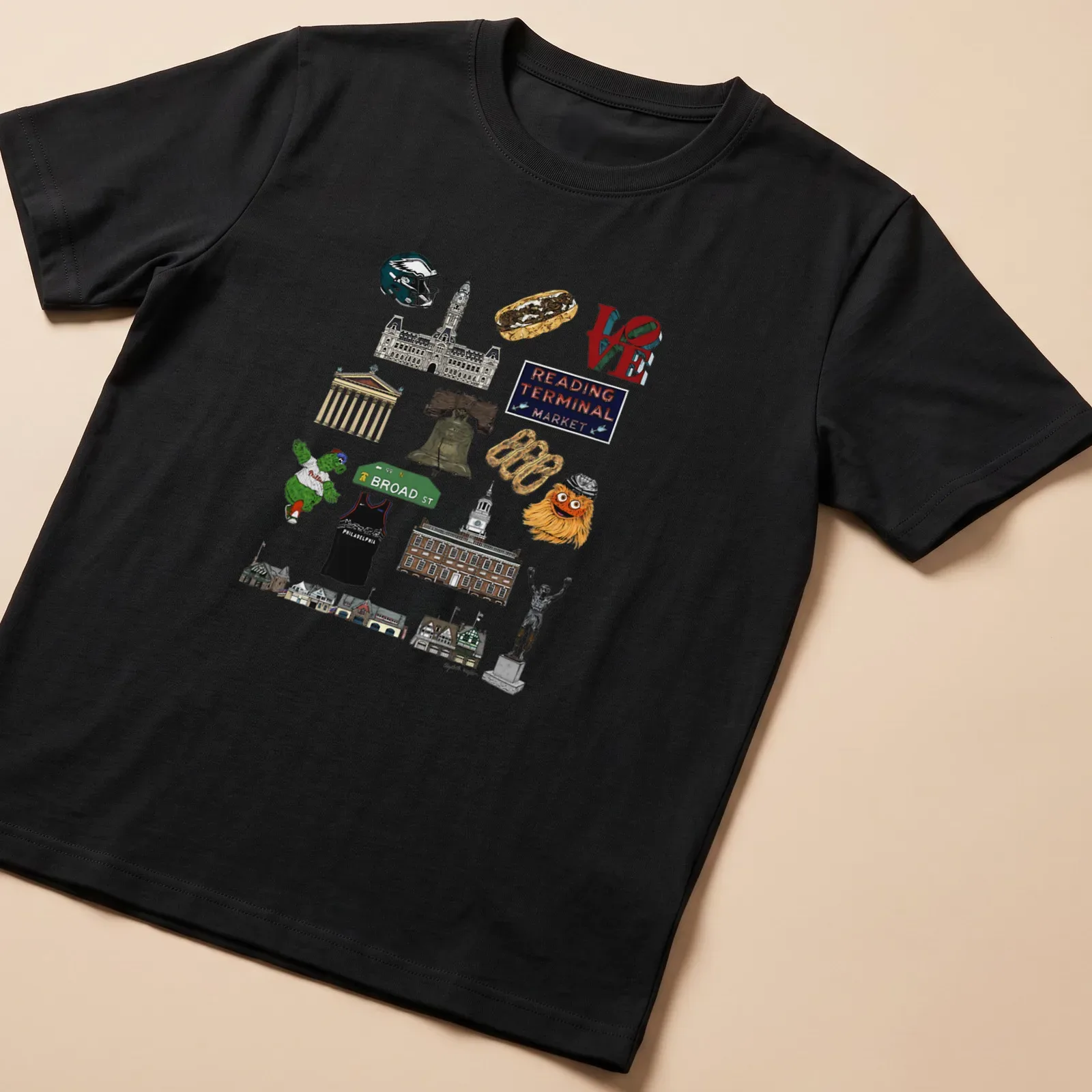 Collage illustration of Philadelphia landmarks in green, yellow, red, blue, brown, and white — printed on a unisex t-shirt