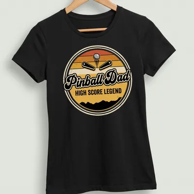Retro arcade tee featuring a pinball machine with 'Pinball Dad HIGH SCORE LEGEND' text in vintage style — printed on a women's shirt
