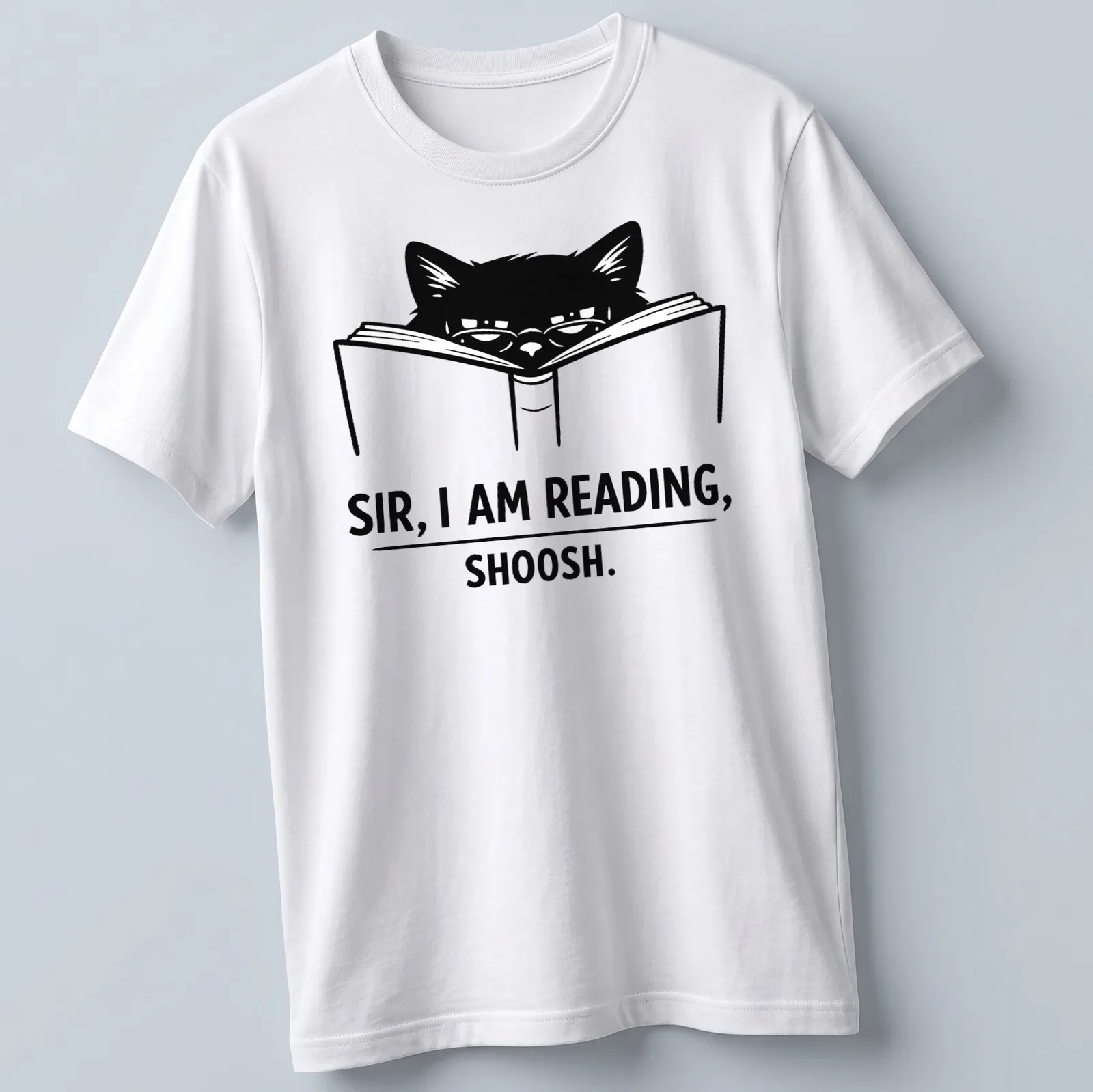 Bold line-art of a cat reading a book with text: 'SIR, I AM READING, SHOOSH.' — printed on a unisex t-shirt