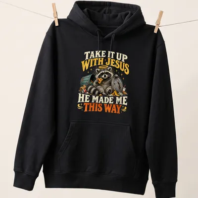 Vintage illustration of a raccoon with text: Take It Up With Jesus He Made Me This Way — printed on a unisex hoodie