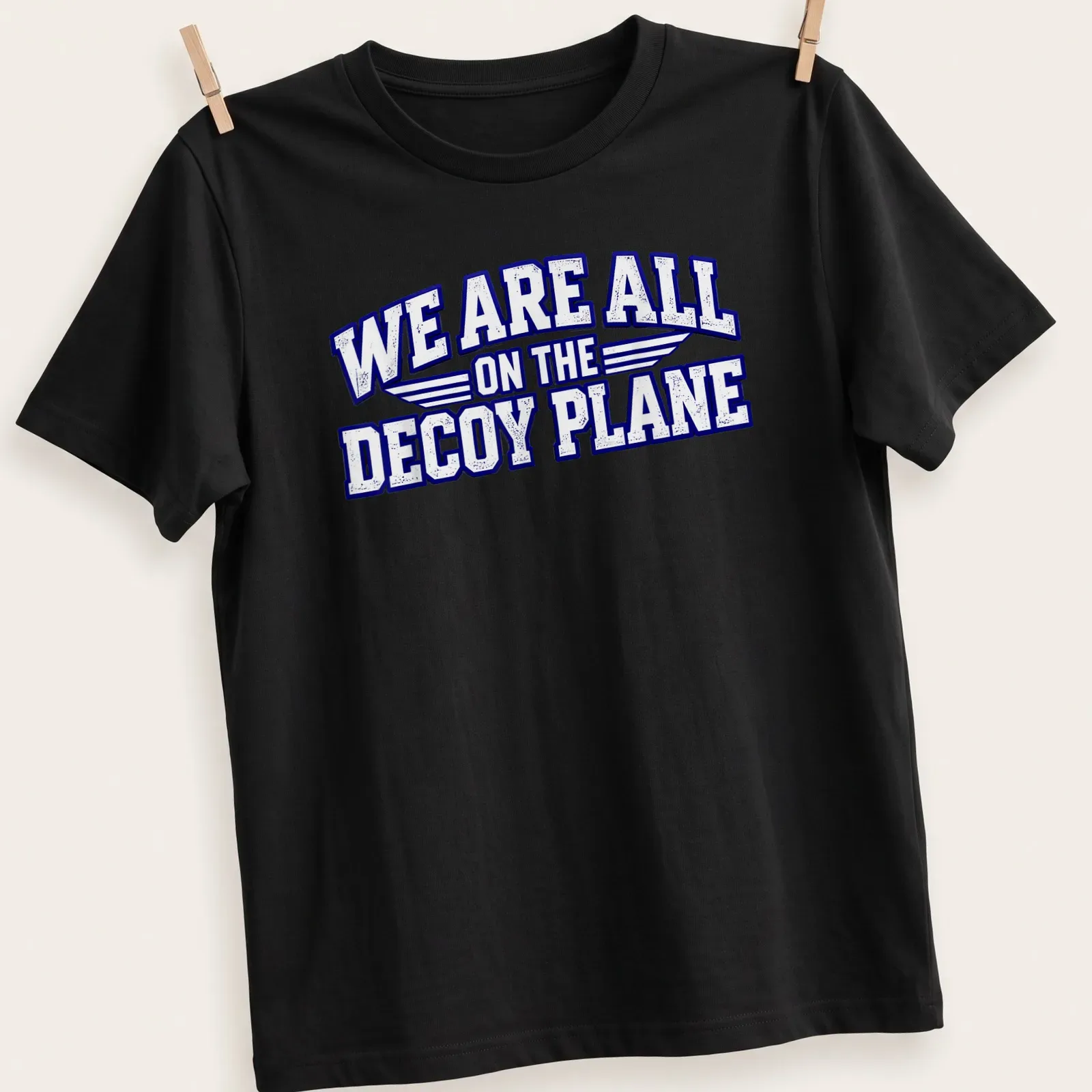 Bold distressed text on a T-shirt featuring a decoy plane design. — printed on a unisex t-shirt