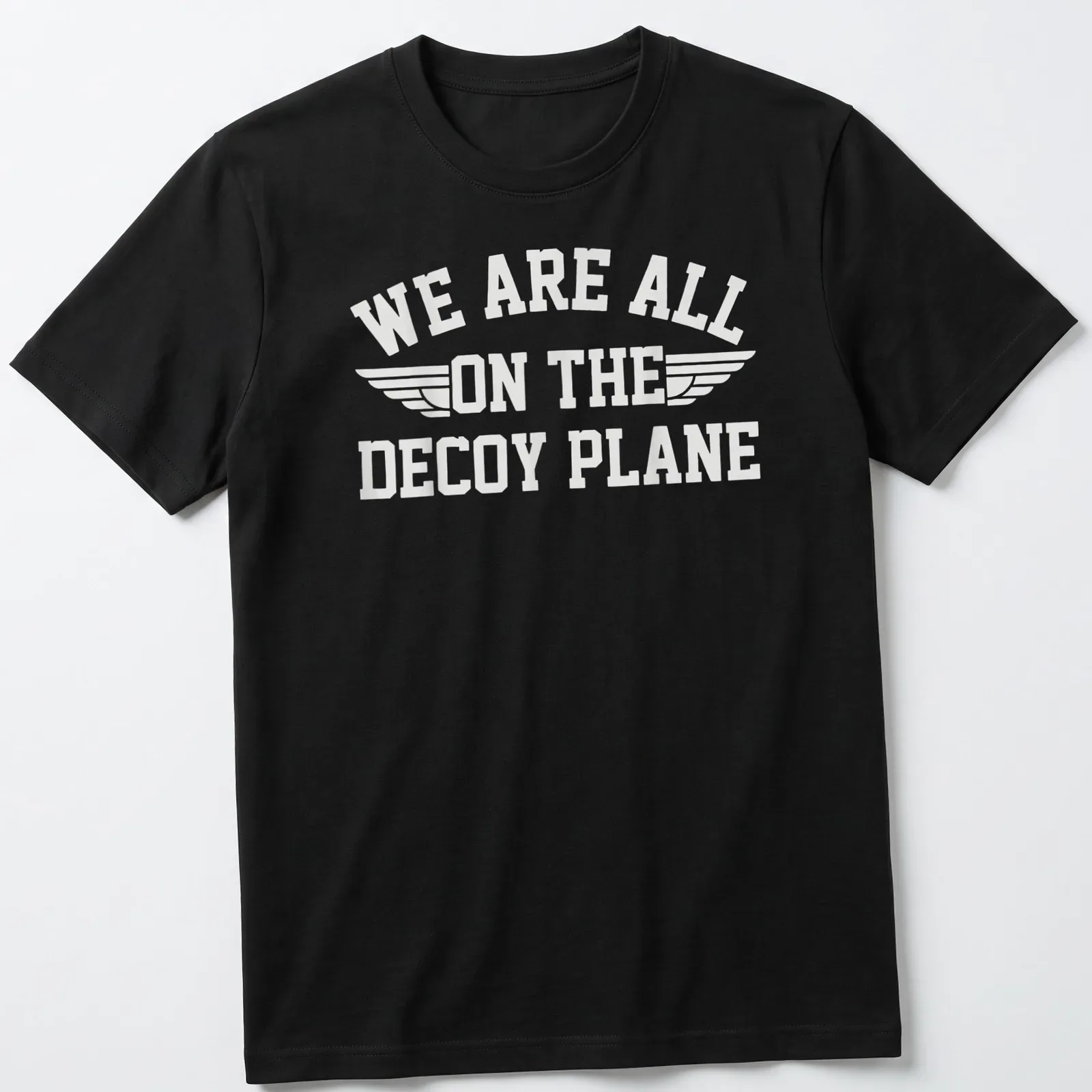 Bold typography t-shirt with the phrase 'We Are All On The Decoy Plane' and wings design in white — printed on a unisex t-shirt