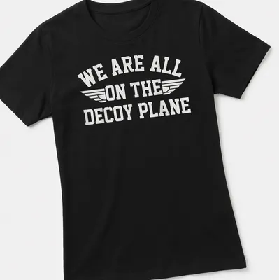 Bold typography t-shirt with the phrase 'We Are All On The Decoy Plane' and wings design in white — printed on a women's shirt